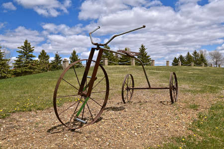 A three wheeled bicycle has been created out of steel rods, but is lacking pedals.の写真素材