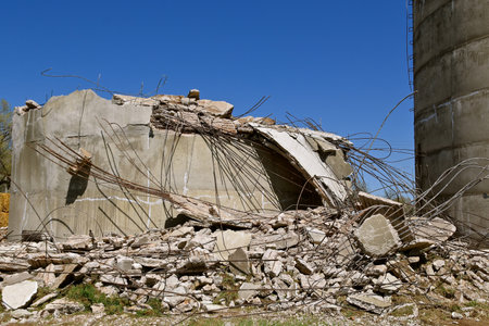 The base of a concrete poured silo remains surrounded by the debris and reinforcing metal rods added...
