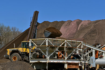 A front end loader with a huge scoop of sand at a construction site of preparing gravelの写真素材
