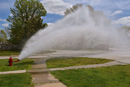 A fire hydrant is open as the system is flushed and tested for operational use when needed.の写真素材