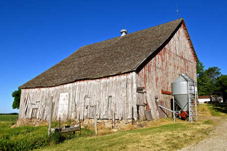 A beautiful weathered horse barn with a hay loft rests on a rock poured foundation.の写真素材