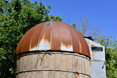 The old stave silo displays a rusty tun roof and a unique metal chute.の写真素材