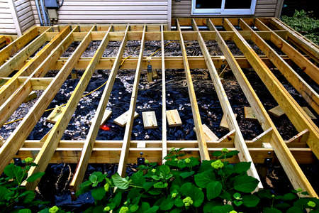The joists, frame, and posts of a new deck under construction are in place.
