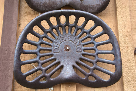NECHE, NORTH DAKOTA, August 10, 2021:  The old rusty tractor seat is a product of Deering  Harvester Co, founded in 1974 ny William Deering.のeditorial素材