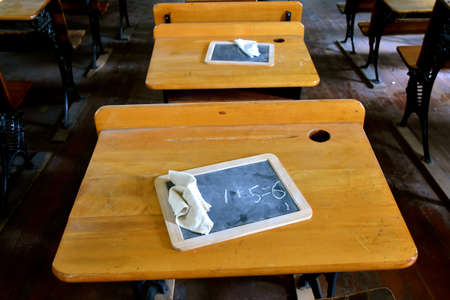 An old rural schoolhouse with wooden desks and a slate boards with chalk for working on lessons.の写真素材