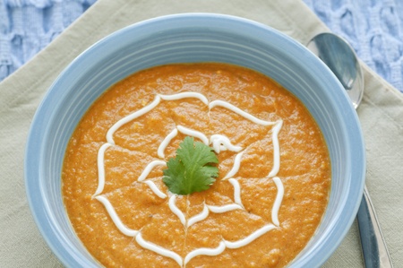 Bowl of bright orange carrot soup garnishの写真素材