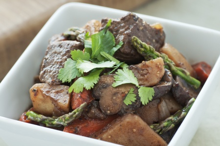 Fresh beef stew with asparagus and cilantro garnishの写真素材