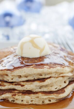 Fresh buttermilk pancakes with scoop of butter on white plateの写真素材