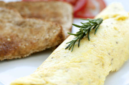 Beautiful golden rolled omelette with toast and her garnishの写真素材