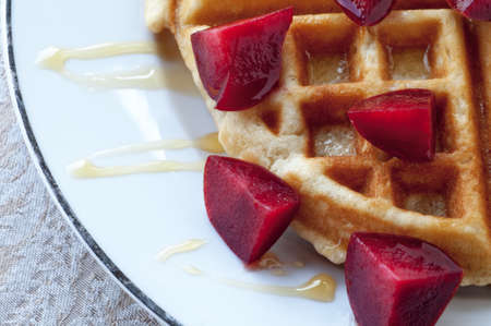 Golden round waffle with honey and fresh pluotsの写真素材