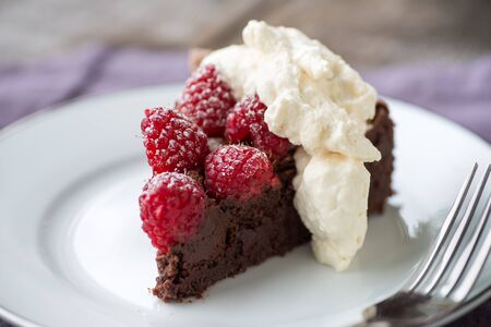 Beautiful flourless chocolate torte with raspberries and powdered sugarの写真素材