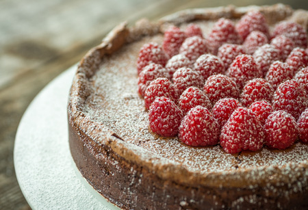 Beautiful flourless chocolate torte with raspberries and powdered sugarの写真素材