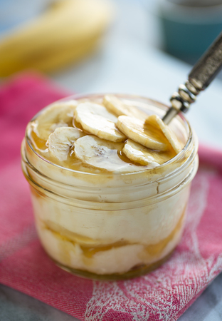 Greek yogurt and raw honey topped with sliced bananasの写真素材