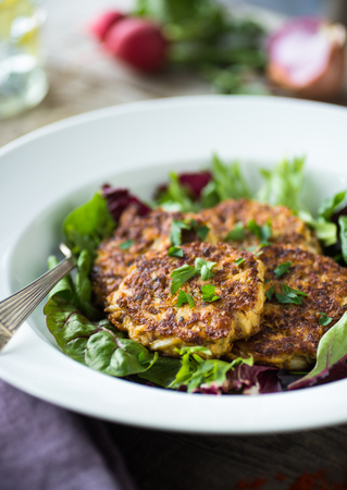 Healthy savory kimchi cakes on a mixed green saladの写真素材