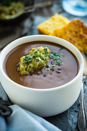 Spicy black bean soup with guacamole and corn breadの写真素材
