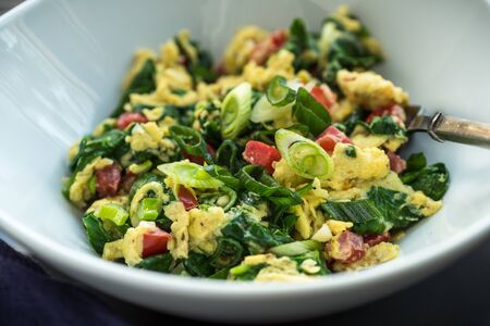 Loaded scrambled eggs with vegetables and green onionsの写真素材