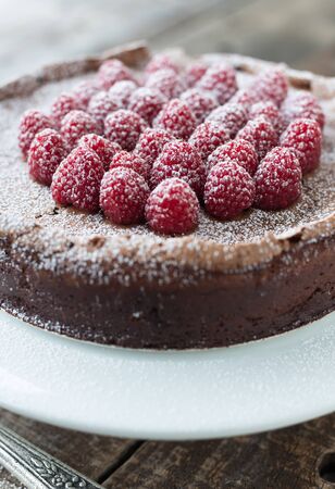 Beautiful flourless chocolate torte with raspberries and powdered sugarの写真素材