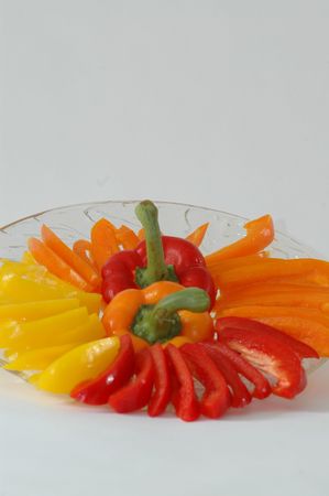 a platter of luscious deep color bell peppers with both a red and orange pepper stem in the centerの写真素材