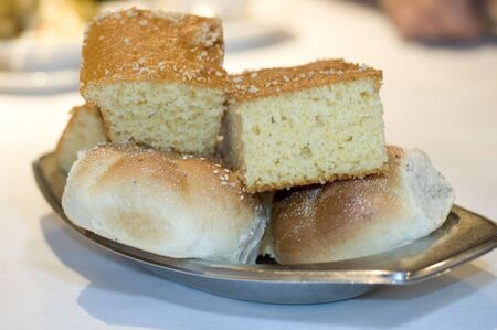 bread rolls bagels cakes in tray on restaurant table