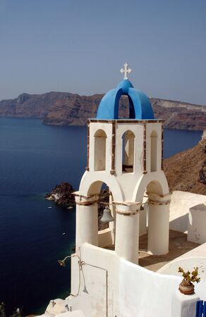 santorini greek church bell tower over sea oia caldera cliffsの写真素材