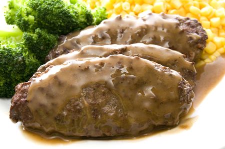 salisbury steak topped with gravy dinner and corn broccoli complete mealの写真素材