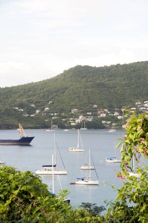 Port Elizabeth harbor with yachts sail boats tankers with view of Hamilton residences Bequia St. Vincent and The Grenadines in Caribbean Seaのeditorial素材