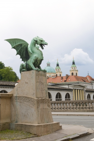 dragon sculpture on Dragon Bridge view of Cathedral Saint Nicholas old city on Ljubljanica River Ljubljana Slovenia Europeの写真素材