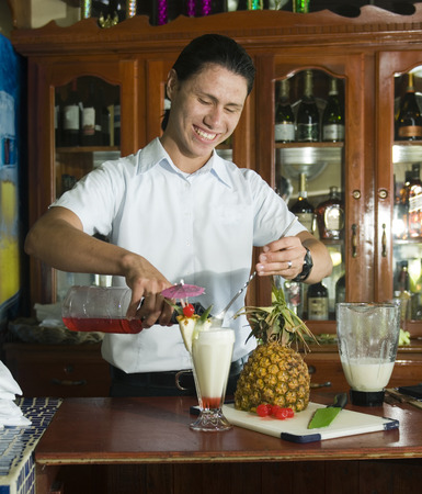Big Corn Island, Nicaragua-April 2: Bartender mixing fresh pineapple pina colada at bar in hotel in Big Corn Island, Nicaragua, Central America on April 2, 2014.のeditorial素材