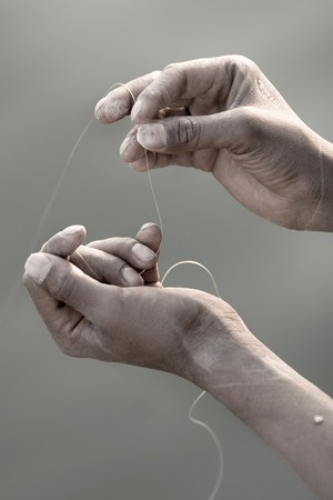 Close up detail of a man's hand holding a fishing netの写真素材