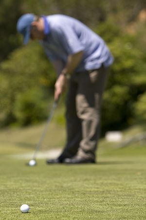 Man playing golf on a fresh green golf course, drive and ball 