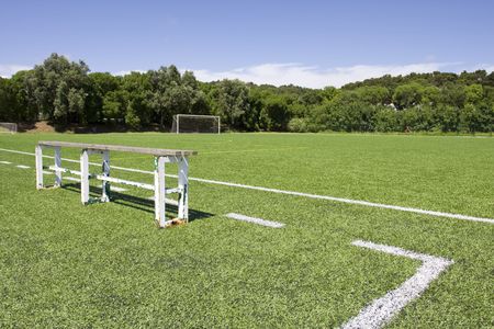 Green grass and sport lines painted at an outdoor playing field with side bank