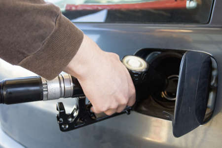 close-up of a mens hand refueling a car at a gas station (Fuel Pump)