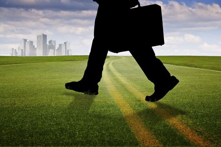 Asphalt pavement through green grass meadowの写真素材