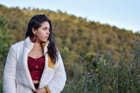 Model woman poses in a forest in the mountain with white and red elegant clothesの写真素材