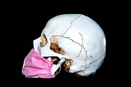 A human skull In Medical Mask on a dark background. Concept Of Deadly Coronavirus Epidemic. covid-19.の写真素材