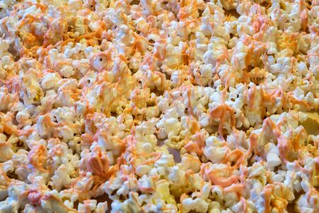 Popcorn with pink colored chocolate drizzled over .の写真素材