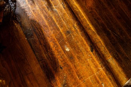 old dark wood floor with texture and shadows.