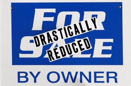 Blue and white drastically reduced real estate sign by ownerの写真素材