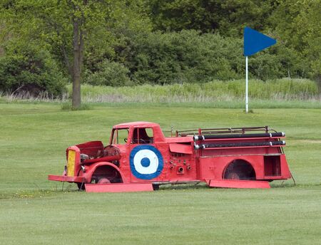 n old junk fire engine on a golf course driving range