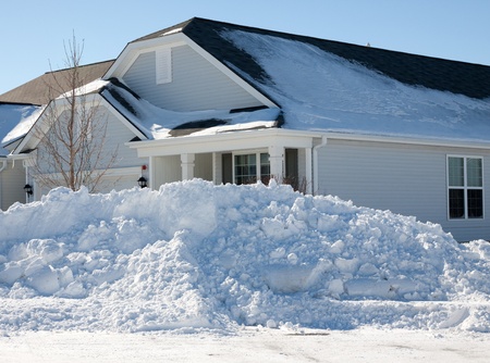 View of corner house with large plowed pile of snow after February blizzard of 2011の写真素材