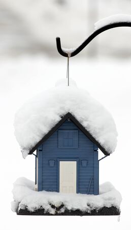 Snow covered blue bird feederの写真素材