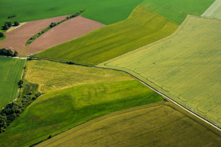 Beautiful green fields and meadows with road in the middle from aboveの写真素材
