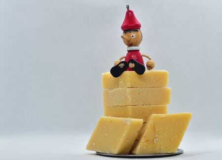 A toy sitting on barfi. Cut in diamond shapes, the rich texture of these desserts render a sweet and nutty feel to the mouths.の写真素材