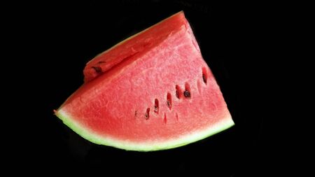 Watermelon with slices isolated on black backgroundの写真素材