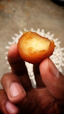 A sweet Gulab jamun captured while eating with his hand