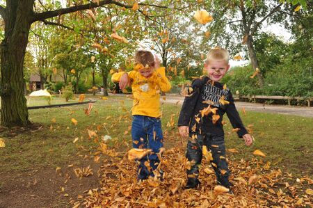 Worms, Germany - October 7, 2009: Children playing with leaves in fall in a public park, which is threatened to be closed because financial problems of municipalityのeditorial素材