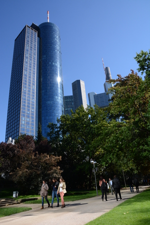 Frankfurt, Germany - October 1, 2015 - Main Tower and Commerzbank Tower seen from Taunusanlage with students walking by Frankfurt, Germany - October 1, 2015 - Main Tower and Commerzbank Tower seen from Taunusanlage with students walking by