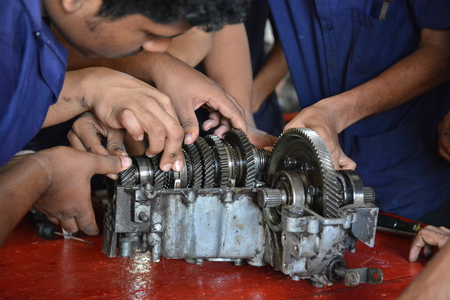 Mumbai, India - October 26, 2015 - Teenager from children«s doing training to become a car mechanician in education center powered by european charity organisation fixing a transmissionのeditorial素材