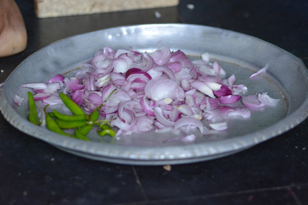 Mumbai, India - October 28, 2015 - Woman cutting chili and onions on a traditional cutting stool  in indian kitchenのeditorial素材