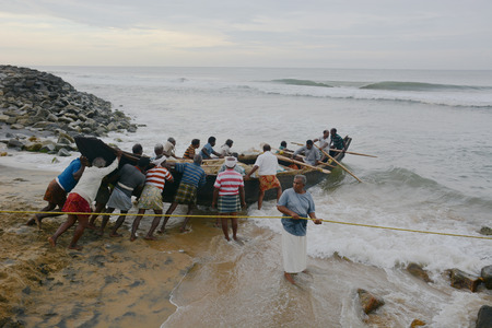 Goa, India - November 5, 2015 - Fishermen catching fishes the traditional way  sharing the catch and bargaining. Pushing their boat into the waterのeditorial素材